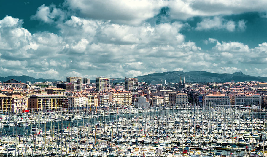 View of cityscape by sea against sky