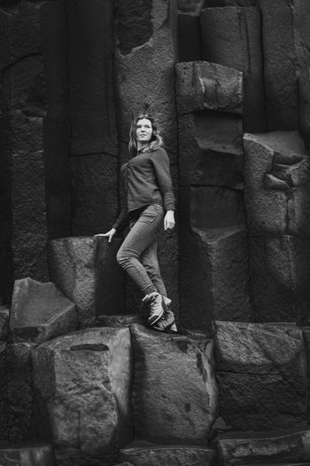 Tourist standing on basalt columns monochrome scenic photography