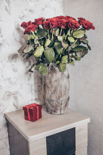 The concept of the holiday. gift in red box and bouquet of roses
