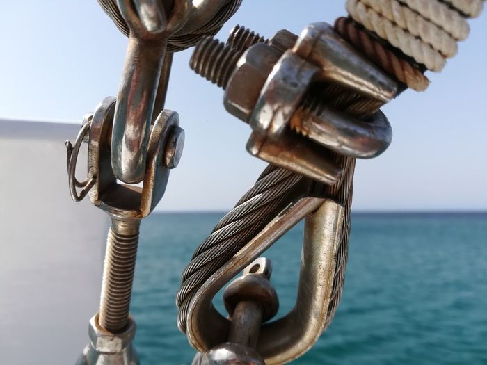 Close-up of metal chain against sky