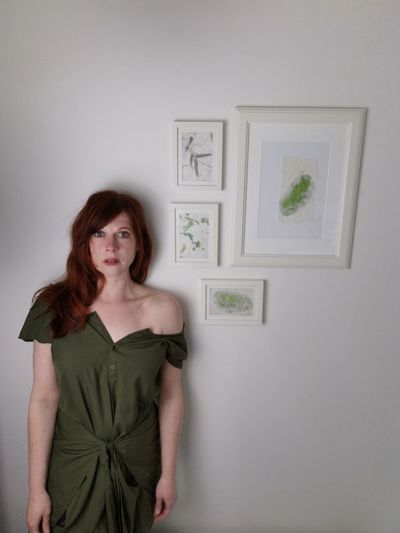 Portrait of a young woman standing against wall