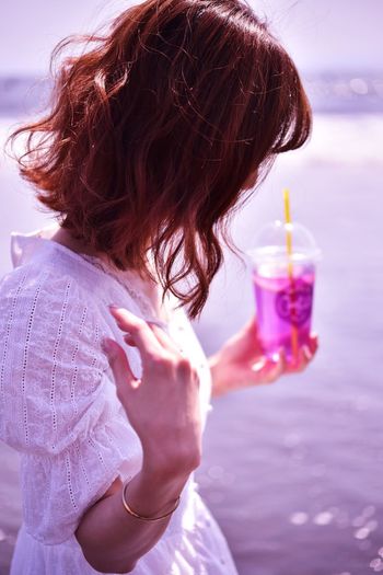 MIDSECTION OF WOMAN HOLDING CHOCOLATE AT BEACH