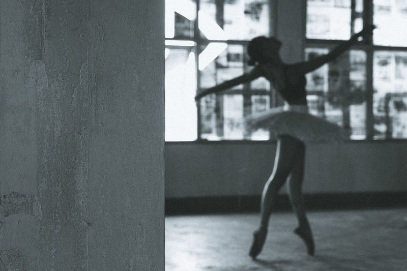 Side view of woman standing by window