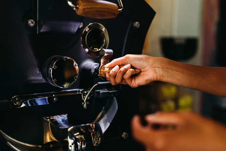 Cropped image of woman using coffee machine