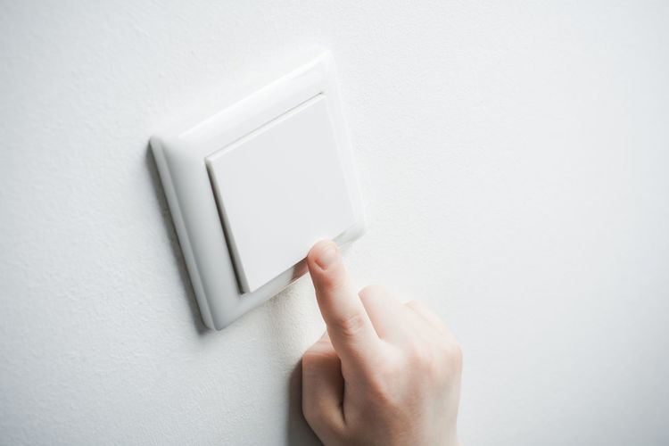 Close-up of human hand on white wall
