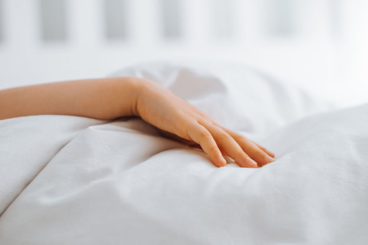 Low section of woman lying on bed at home