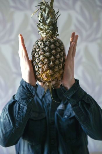 Close-up of man holding pineapple