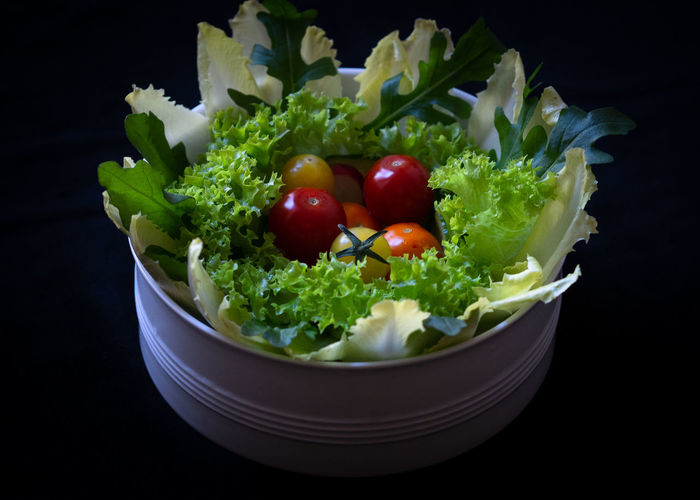 Close-up of chopped fruits in bowl against black background