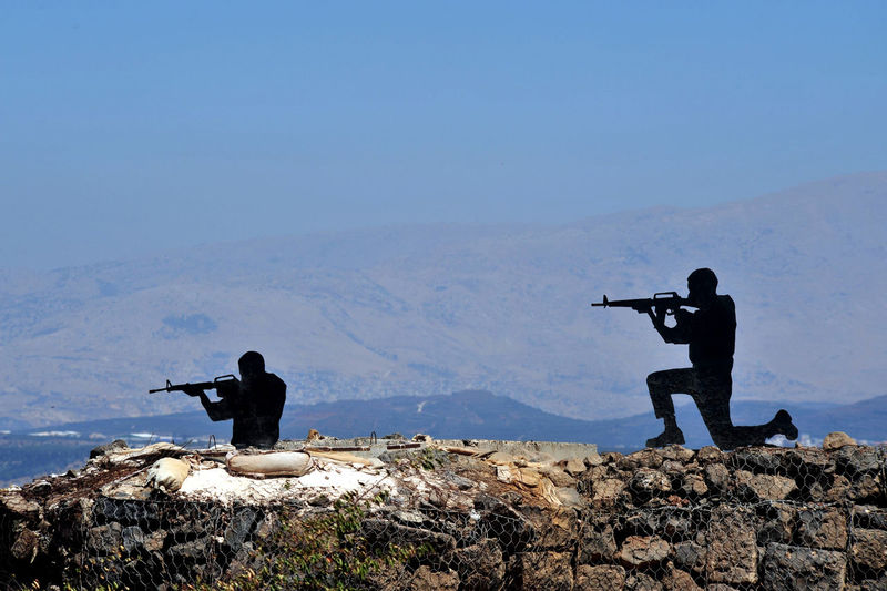 Army soldiers shooting with rifles against clear sky