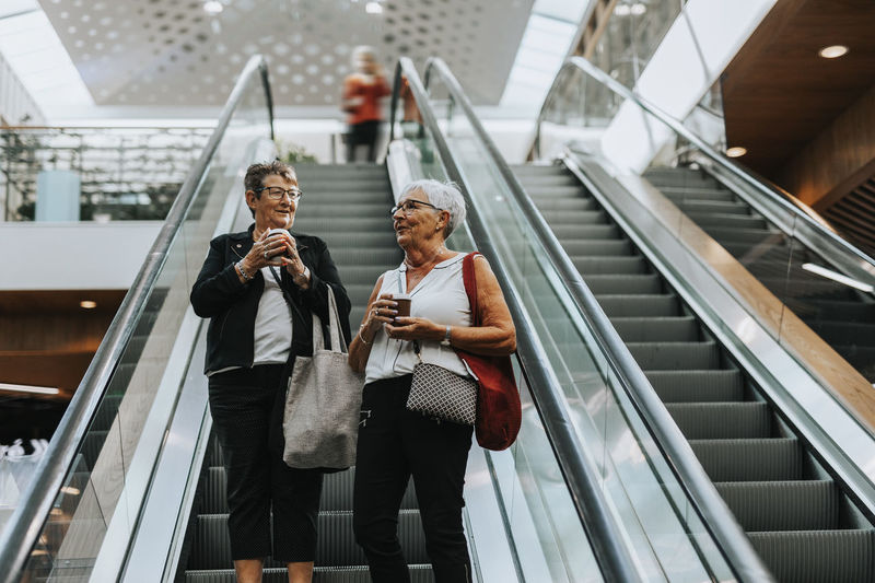 Senior women standing on escalator