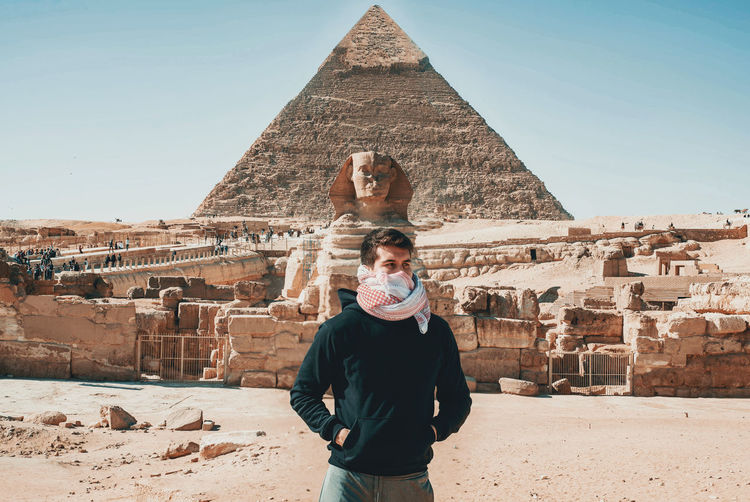 Portrait of man standing against the wonder of the worldpyramids in egypt