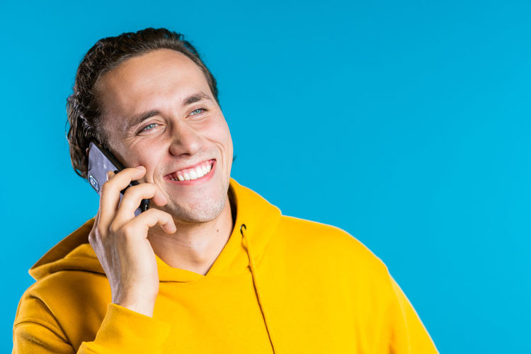 Portrait of smiling young man using mobile phone