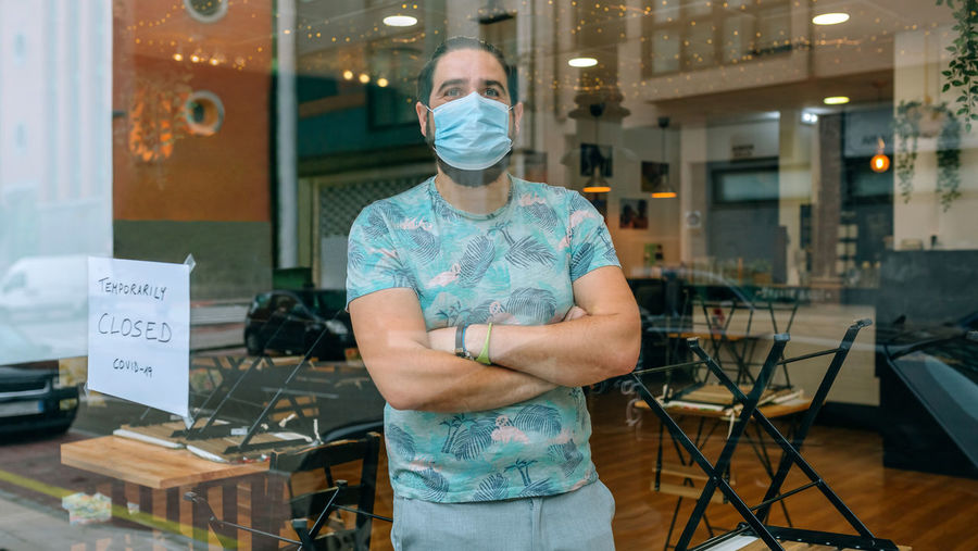 Man behind the glass of his restaurant closed by covid-19