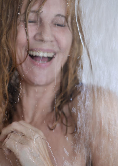 Close-up portrait of a smiling young woman in water
