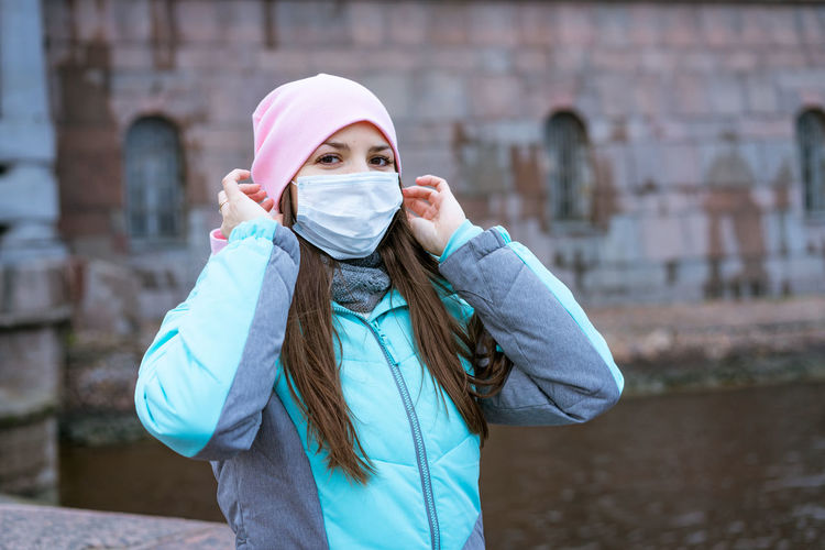 Portrait of woman wearing mask standing outdoors