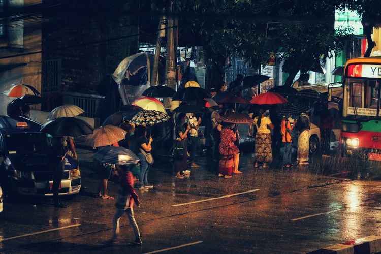People on wet street during rainy season at night