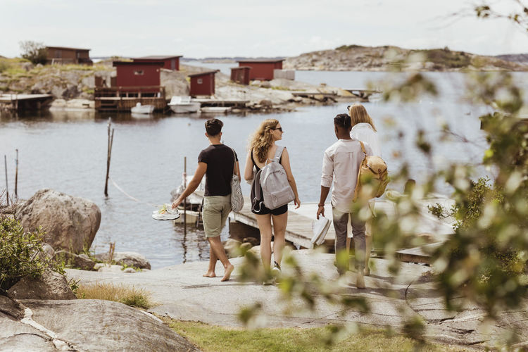 Rear view of friends looking at sea during summer vacation