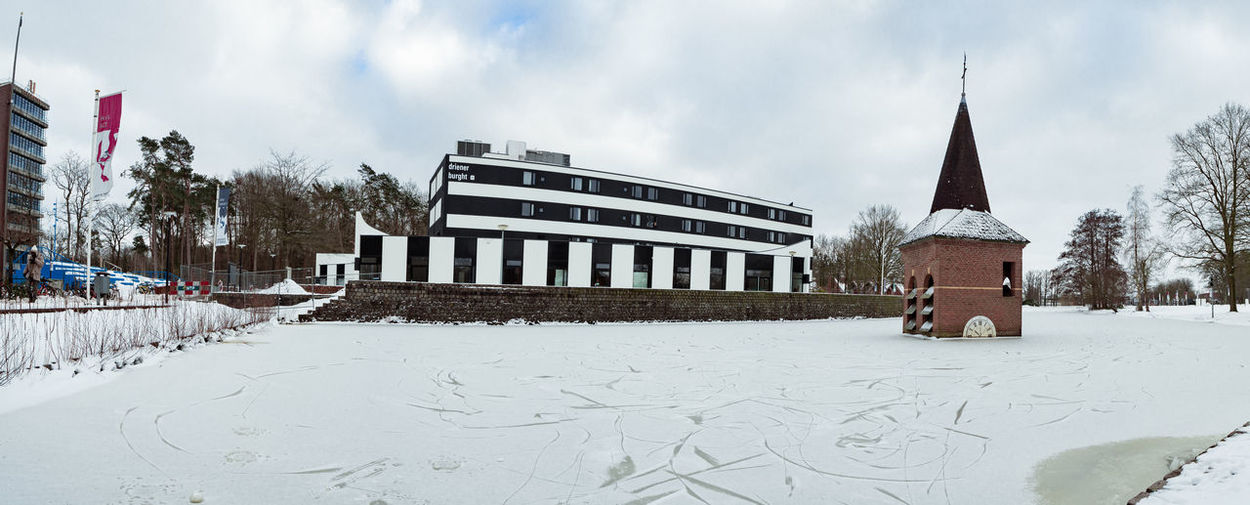 Panoramic view of snow covered buildings against sky