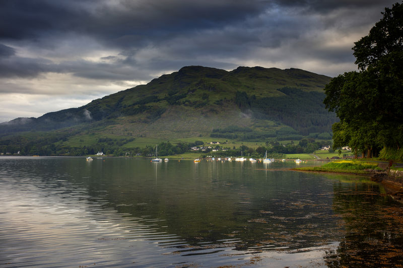 Scenic view of lake by mountains against sky