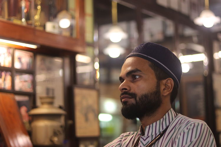 A muslim waiter with a thoughtful look at an irani cafe  in mumbai