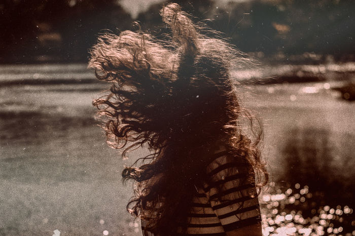 Woman with tousled hair by lake
