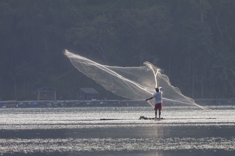 Fishermen look for fish with bamboo rafts in ranu klakah lake