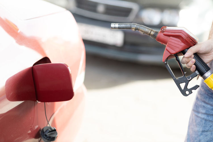 Cropped hand of man refueling car at petrol station