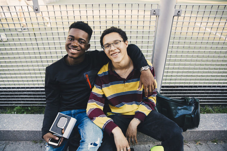 Portrait of smiling young couple sitting outdoors