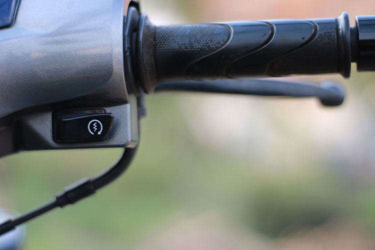 Close-up of power button on handle bar of motorbike.