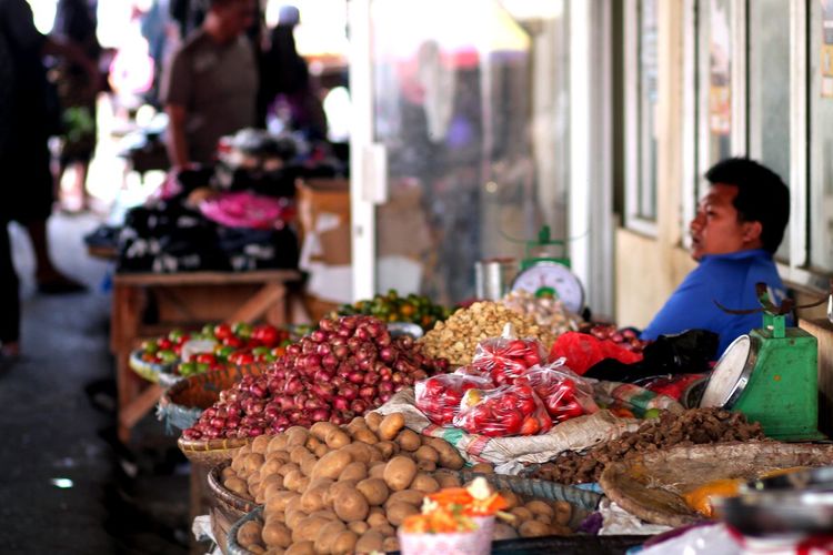 Vendor selling various fruits at market stall