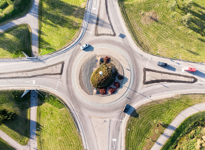 A roundabout from a drone point of view. there are a couple of cars driving in and out. 