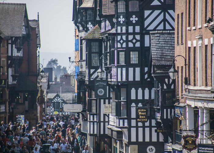 Group of people on street against buildings in chester, england 