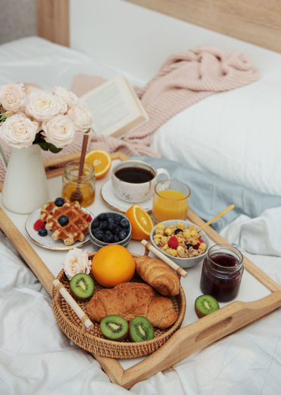 Romantic breakfast with coffee, waffles, orange juice and rose flowers.