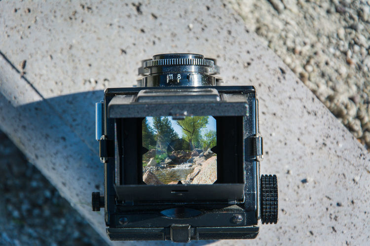 Close-up of vintage camera on retaining wall