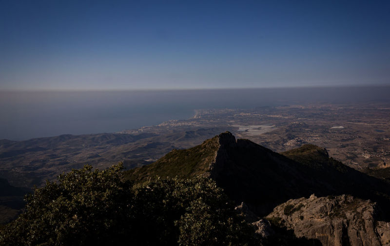 Scenic view of sea and mountains against clear sky