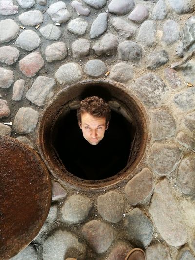 Full length of man standing in manhole