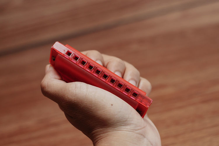 Close-up of hand holding harmonica