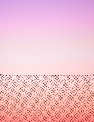 Fence against sky during sunset