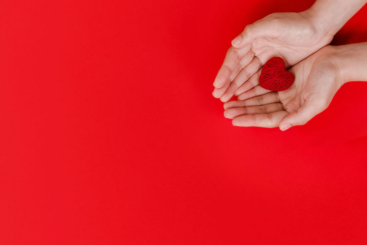 Close-up of hand holding red umbrella