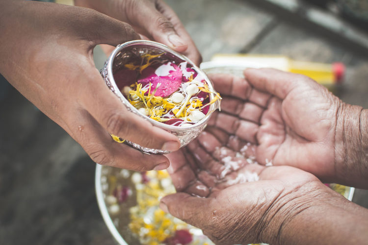 Cropped hand of people performing rituals