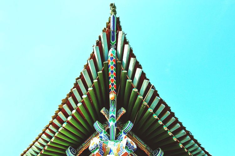 Low angle view of ferris wheel against clear blue sky