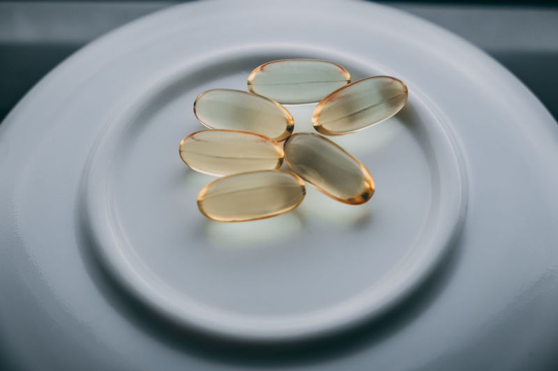 Yellow transparent capsules omega 3 lie on a white background. healthy food concept
