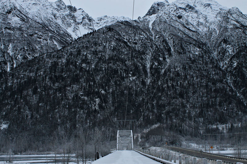 Falling snow on bridge with mountain winter background