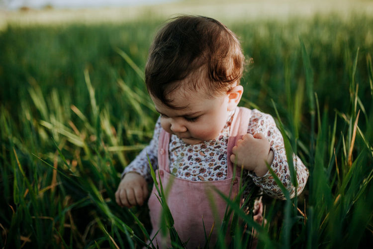 Cute baby girl by plants