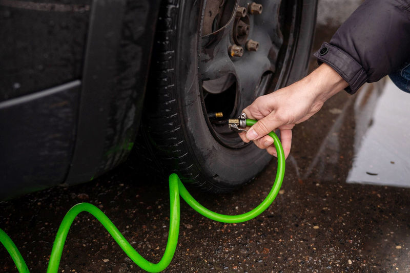Men's hands hold a pump for a car tire