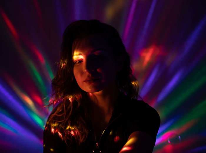 Thoughtful woman in illuminated nightclub