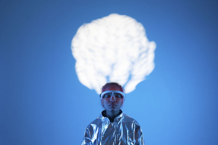 Woman with eyes closed under cloud computing against blue background
