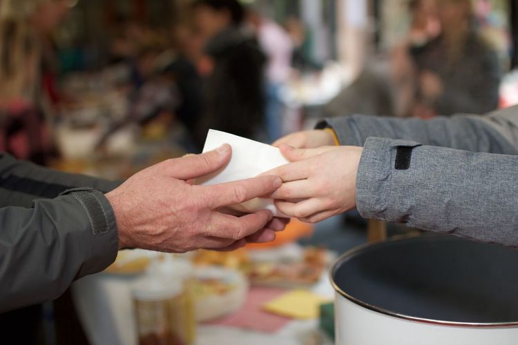 Cropped image of volunteer giving food to person
