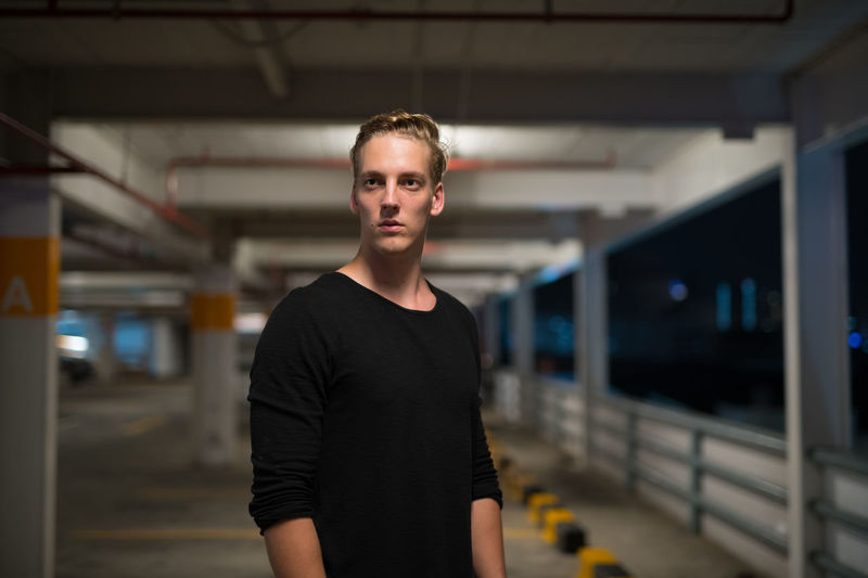 Portrait of young man standing at railroad station