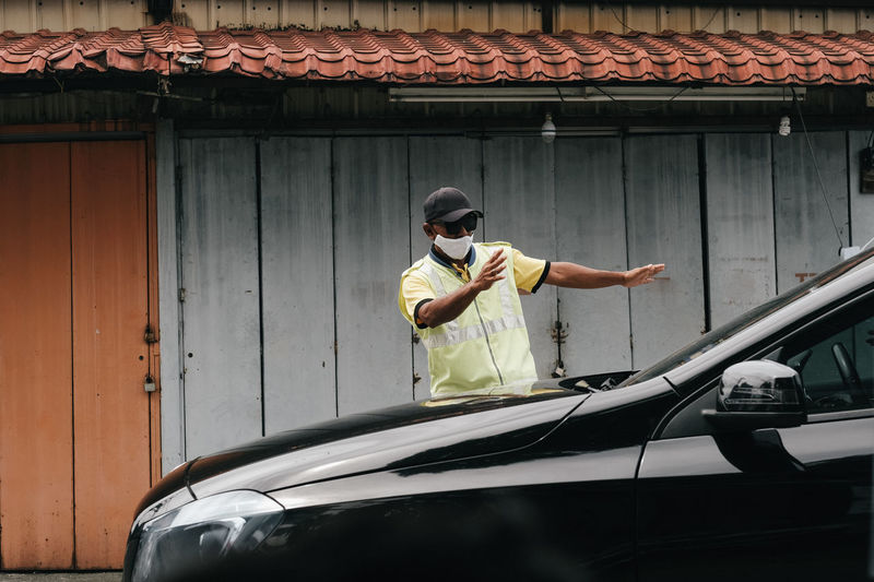 Man wearing mask stopping car in city
